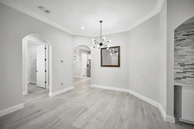 a view of a room with wooden floor and chandelier
