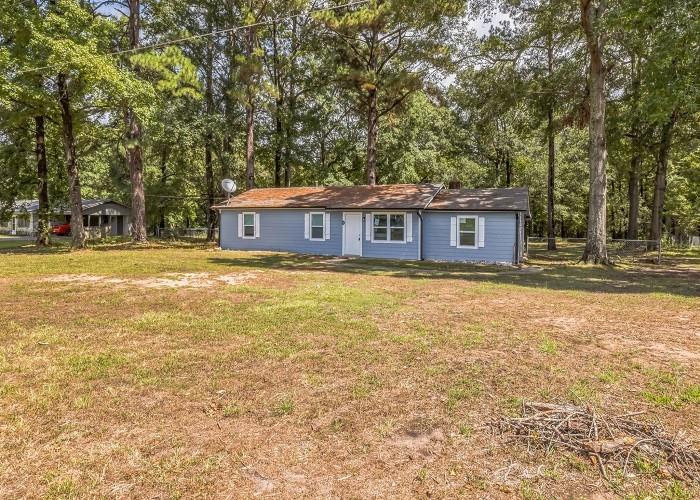 159 County Road 1230 Texarkana, TX 75501 - Photo 1 of 1 a view of a house with a big yard and large trees