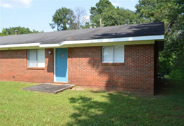 a view of house with backyard space and garden