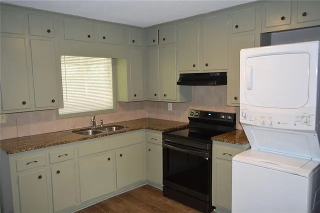 a kitchen with a sink and a stove top oven