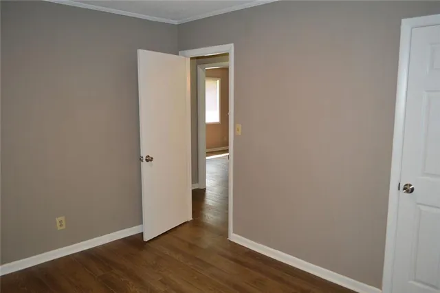 an empty room with wooden floor and closet