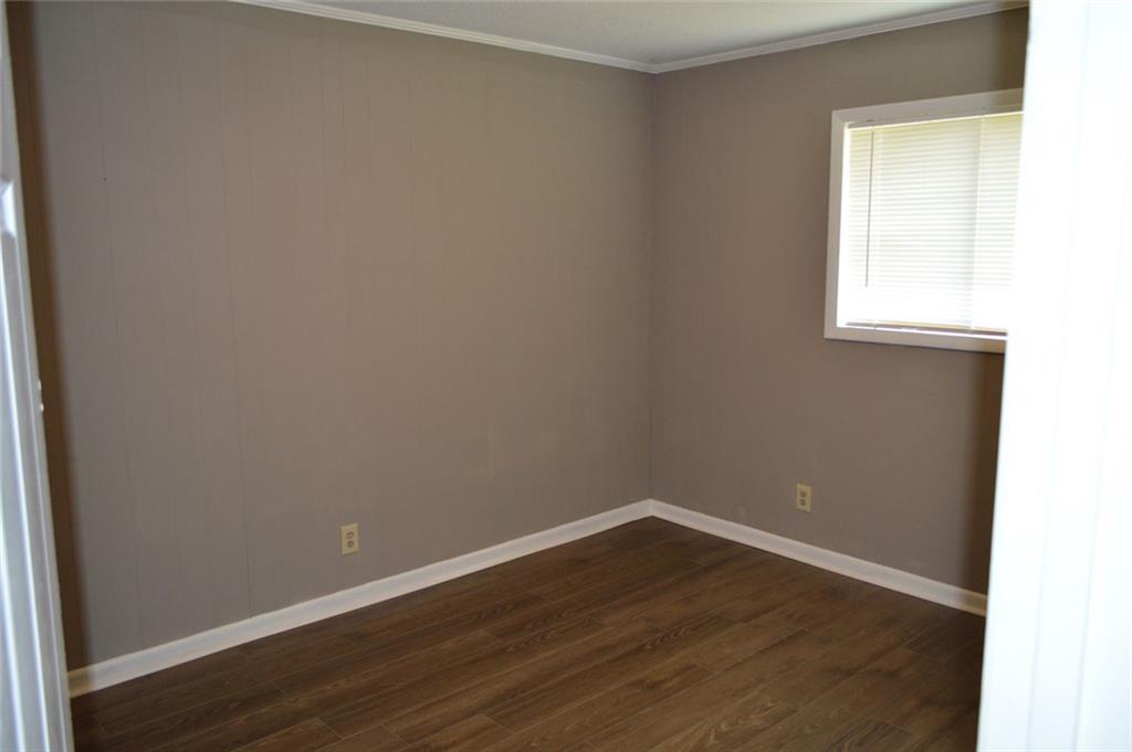 8859 Main Street, Unit 2 Woodstock, GA 30188 - Photo 9 of 12 an empty room with wooden floor and windows