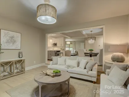 a living room with furniture and a view of kitchen