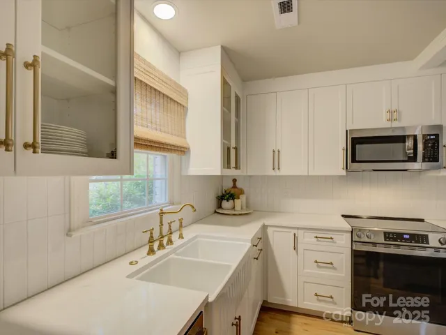 a kitchen with a sink a stove and cabinets