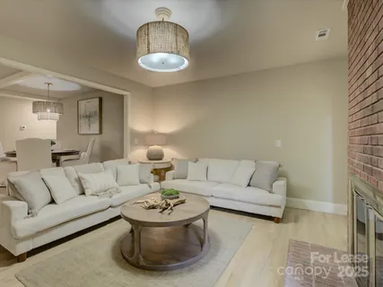 a living room with furniture and a chandelier