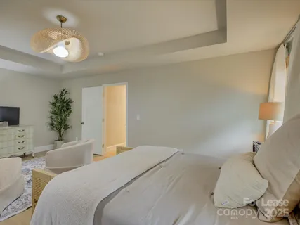 a bedroom with a large bed and a chandelier