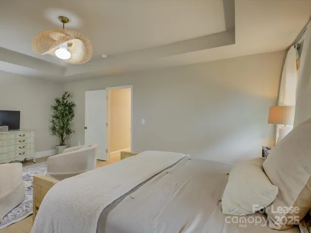 a bedroom with a large bed and a chandelier