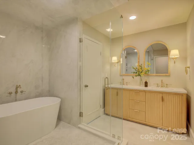 a bathroom with a tub sink and mirror