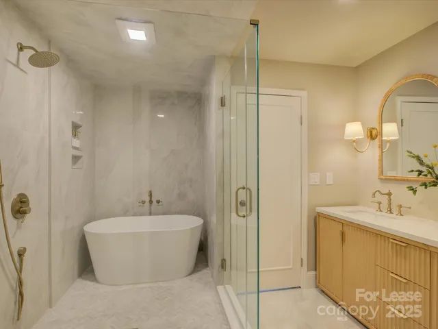 a bathroom with a white tub shower sink and vanity