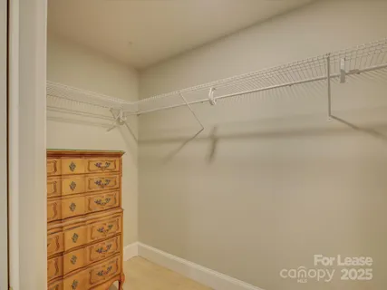 a view of walk in closet with empty racks