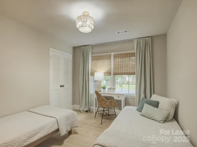 a bedroom with a bed and a large window