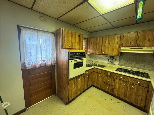 a kitchen with wooden cabinets and a stove top oven