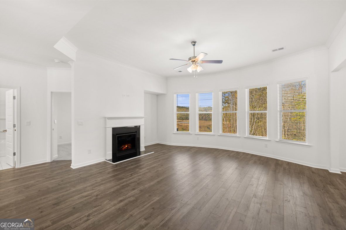 408 Hazel Drive Locust Grove, GA 30248 - Photo 11 of 32 a view of an empty room with wooden floor fireplace and a window