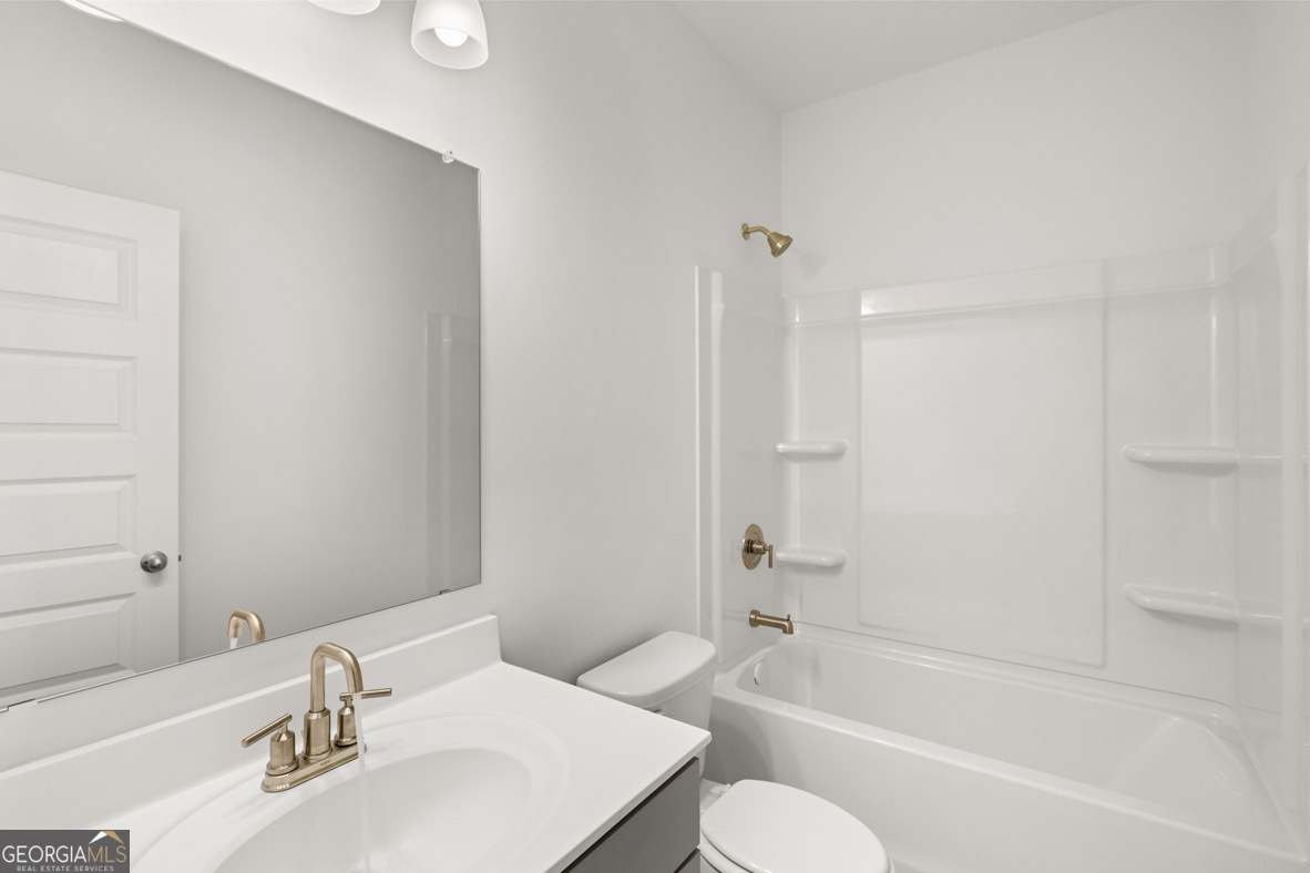 408 Hazel Drive Locust Grove, GA 30248 - Photo 14 of 32 a bathroom with a bathtub shower sink and a toilet