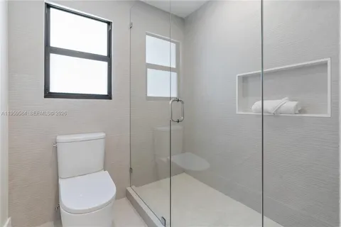 a white toilet sitting next to a bathroom sink