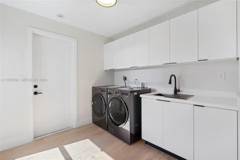 a utility room with sink dryer and washer