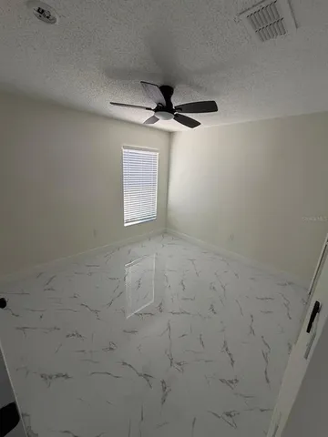 a view of a livingroom with a ceiling fan and window