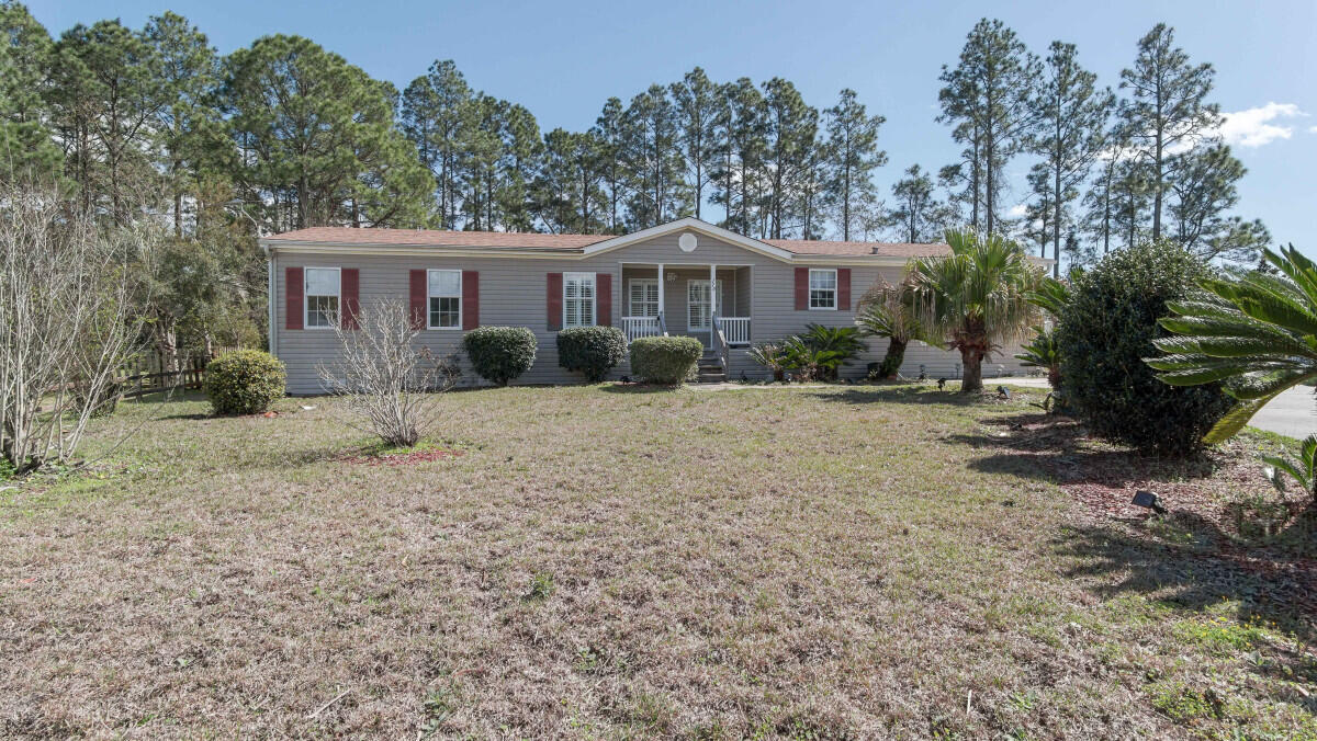 a front view of a house with a yard and trees