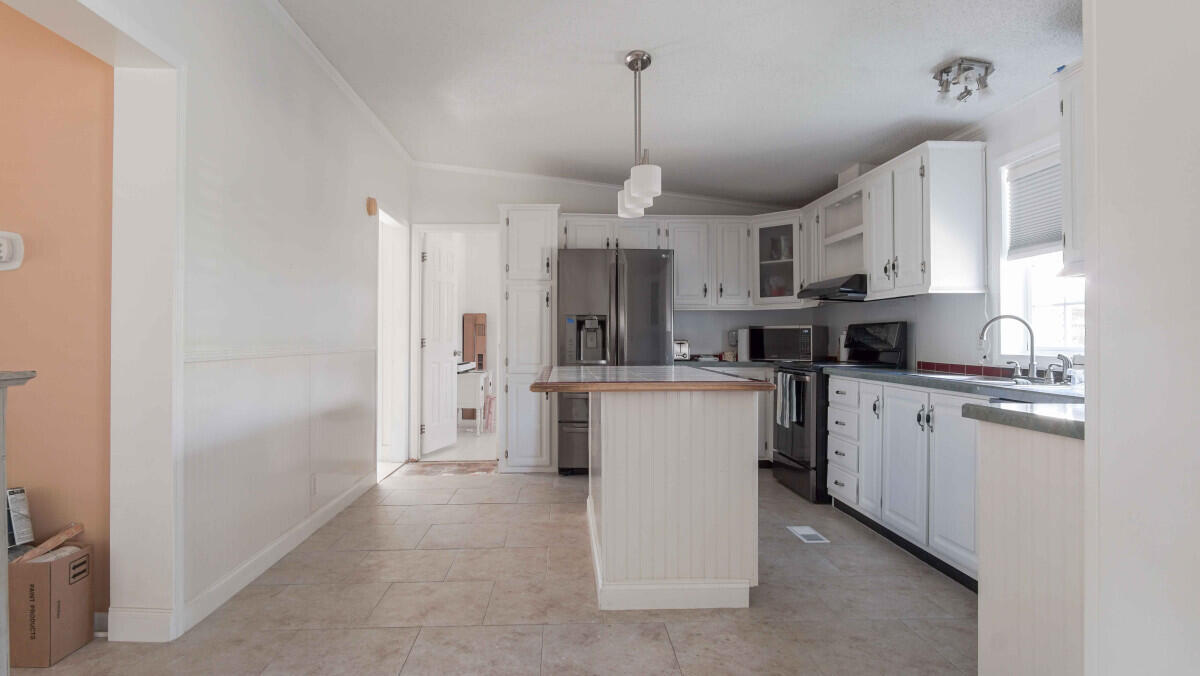 119 Edgewood Terrace Santa Rosa Beach, FL 32459 - Photo 5 of 23 a kitchen that has a refrigerator a stove and white cabinets