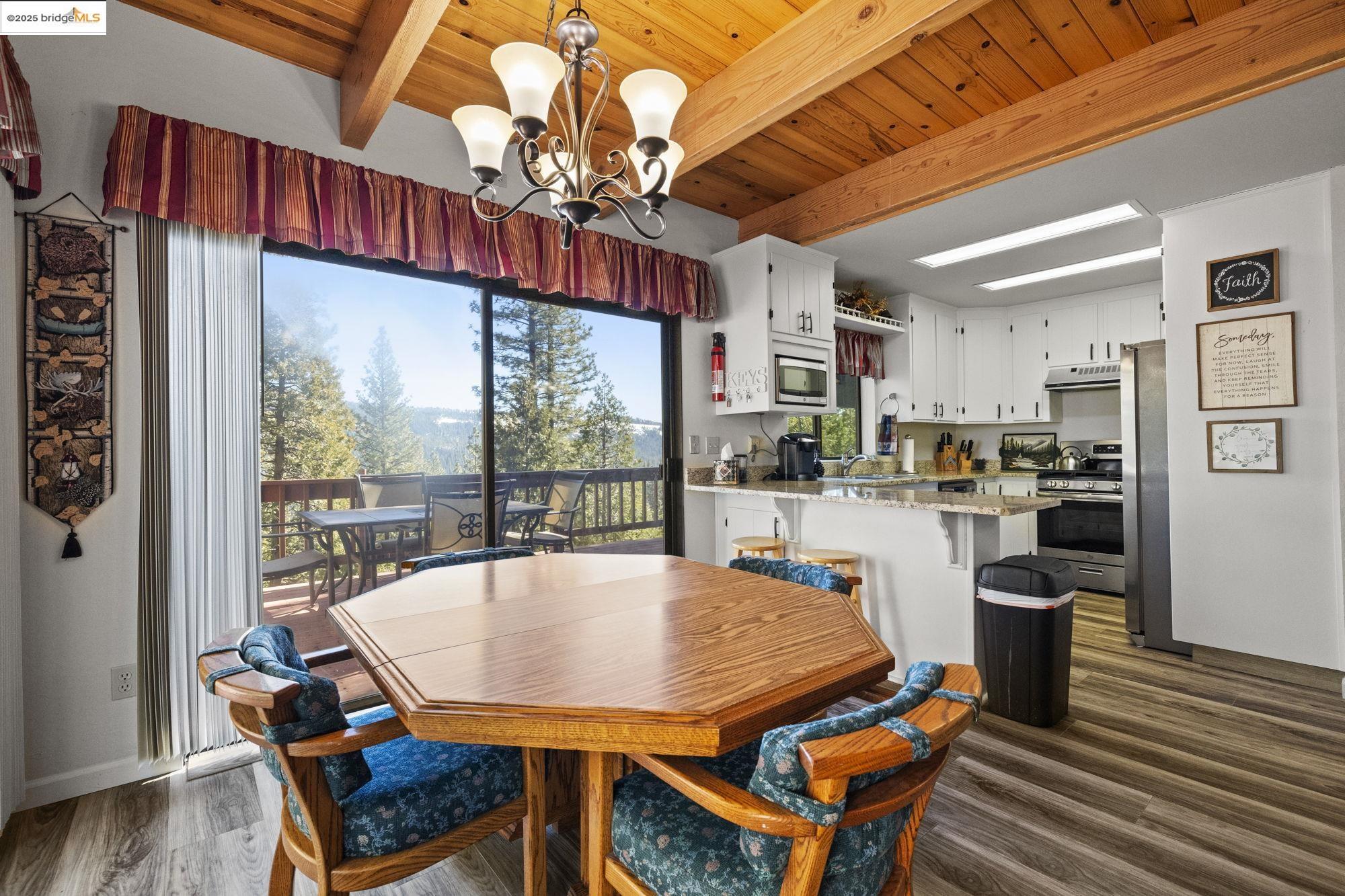 29803 West Mono Road Cold Springs, CA 95335 - Photo 7 of 51 a view of a dining room with furniture a chandelier and wooden floor