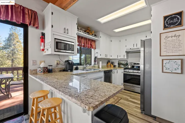 a kitchen with stainless steel appliances granite countertop a stove refrigerator and a sink