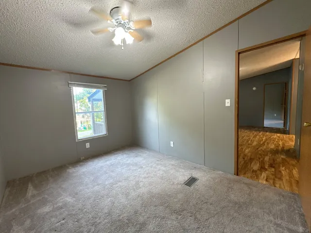 a view of an empty room with a chandelier fan