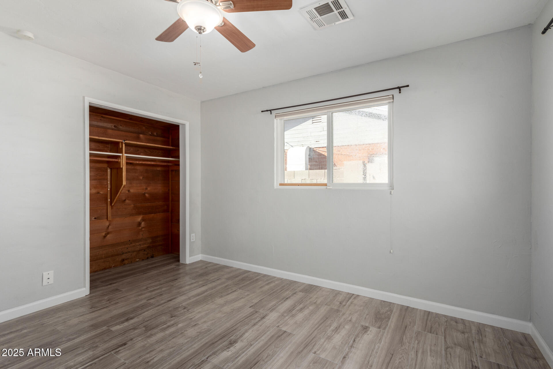 1061 West 5th Street Mesa, AZ 85201 - Photo 17 of 29 an empty room with wooden floor closet and windows