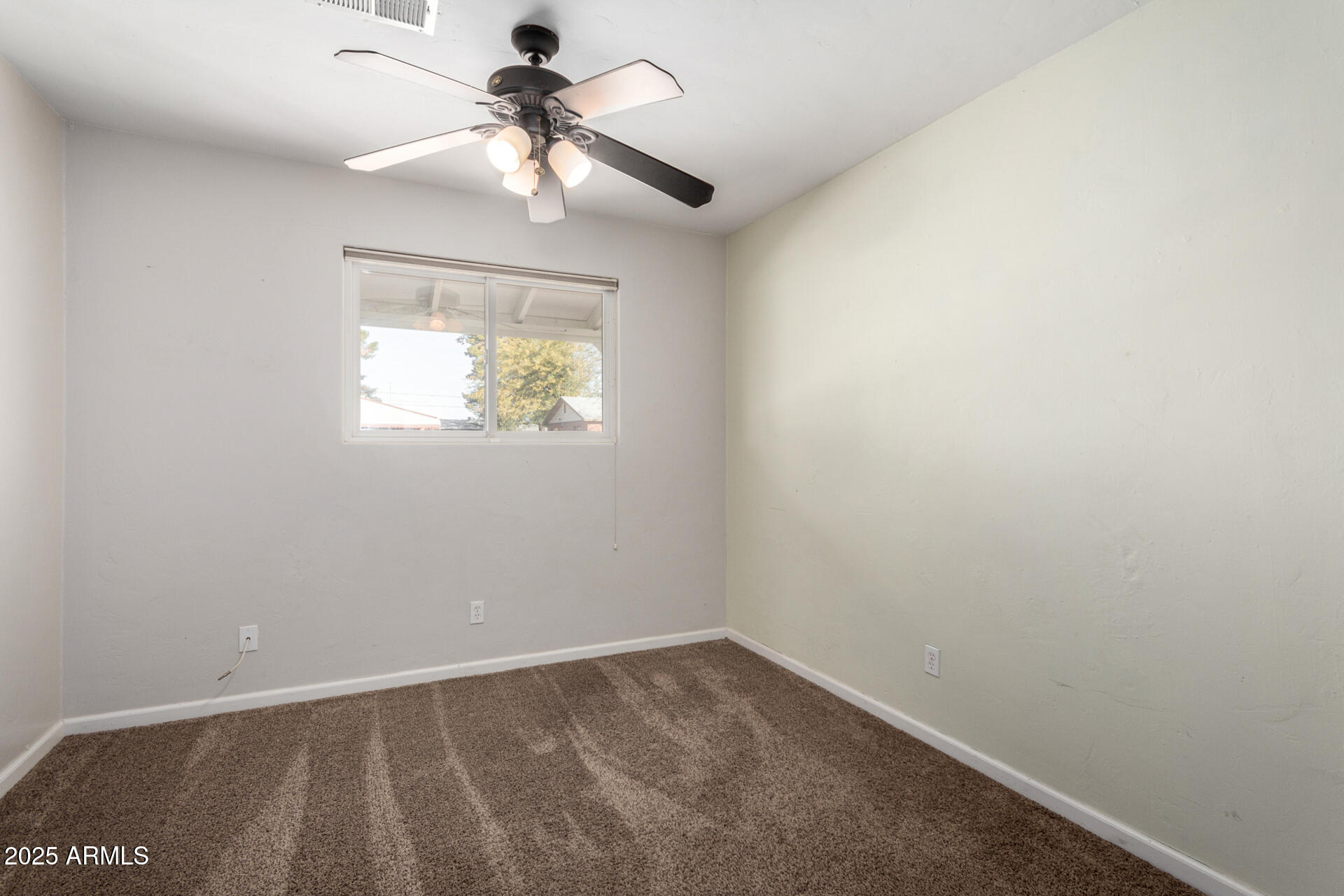 1061 West 5th Street Mesa, AZ 85201 - Photo 19 of 29 an empty room with a chandelier fan and windows