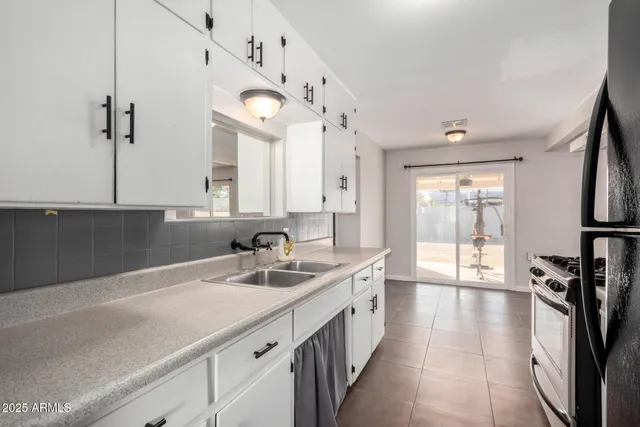 a view of an empty room with cabinet and a window