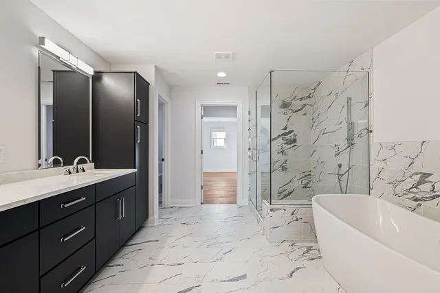 a bathroom with a bathtub sink mirror toilet and shower