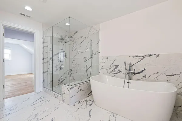 a white bath tub sitting next to a shower