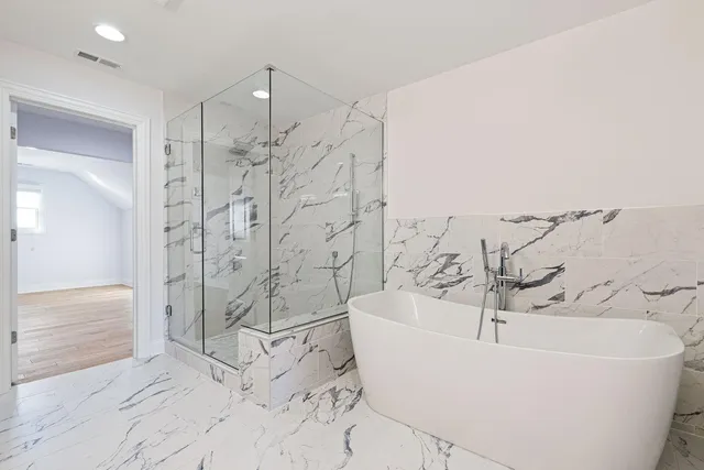 a white bath tub sitting next to a shower
