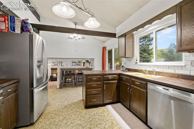 a kitchen with stainless steel appliances granite countertop a stove a sink and a refrigerator