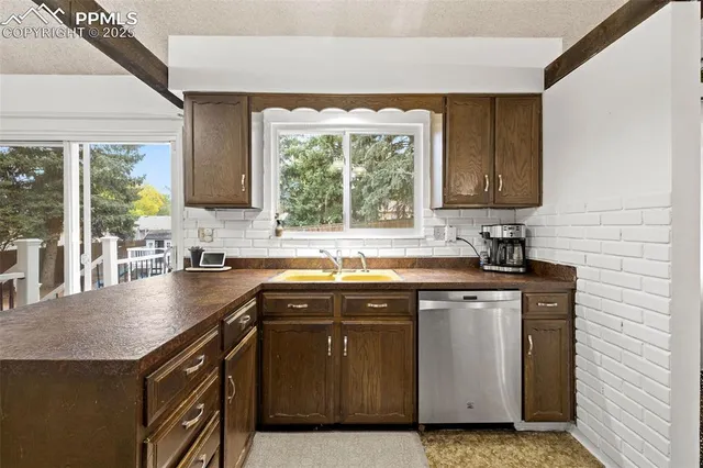 a kitchen with stainless steel appliances granite countertop a sink a stove a counter space and a window