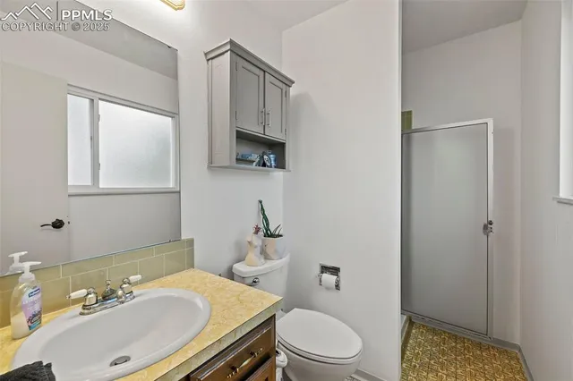 a bathroom with a sink a toilet a mirror and shower