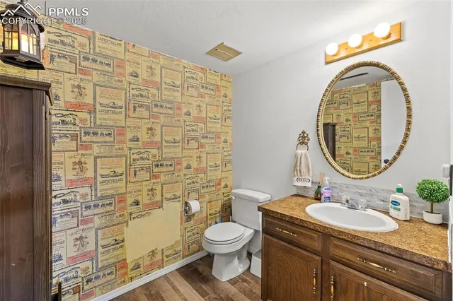 a bathroom with a granite countertop toilet a sink and a mirror