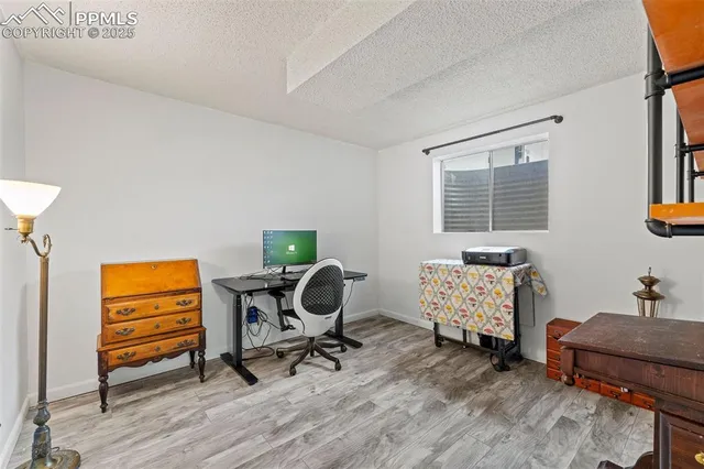 a view of a workspace with furniture and a window