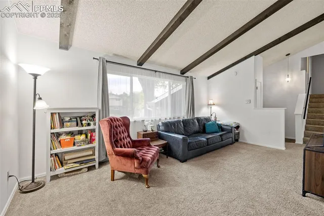 a living room with furniture cabinets and a large window