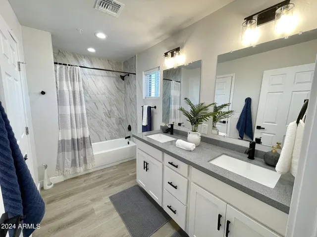 a bathroom with a double vanity sink toilet and shower