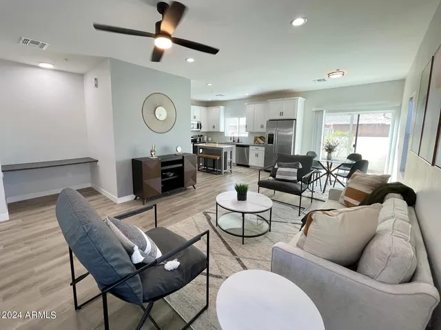 a living room with furniture kitchen view and a window