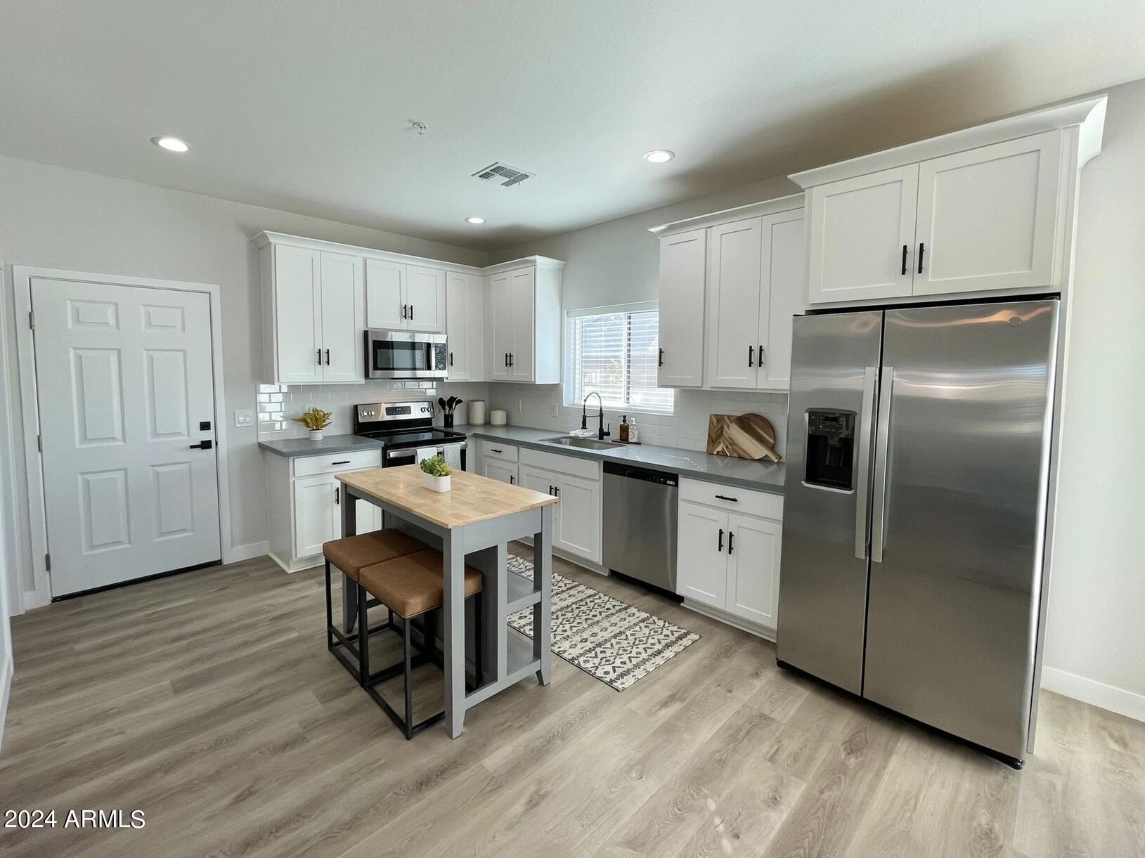 815 East Roma Avenue, Unit 5 Phoenix, AZ 85014 - Photo 6 of 28 a kitchen with stainless steel appliances granite countertop a refrigerator a stove a sink dishwasher and a refrigerator with wooden floor