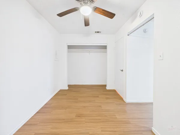 a view of an empty room with wooden floor