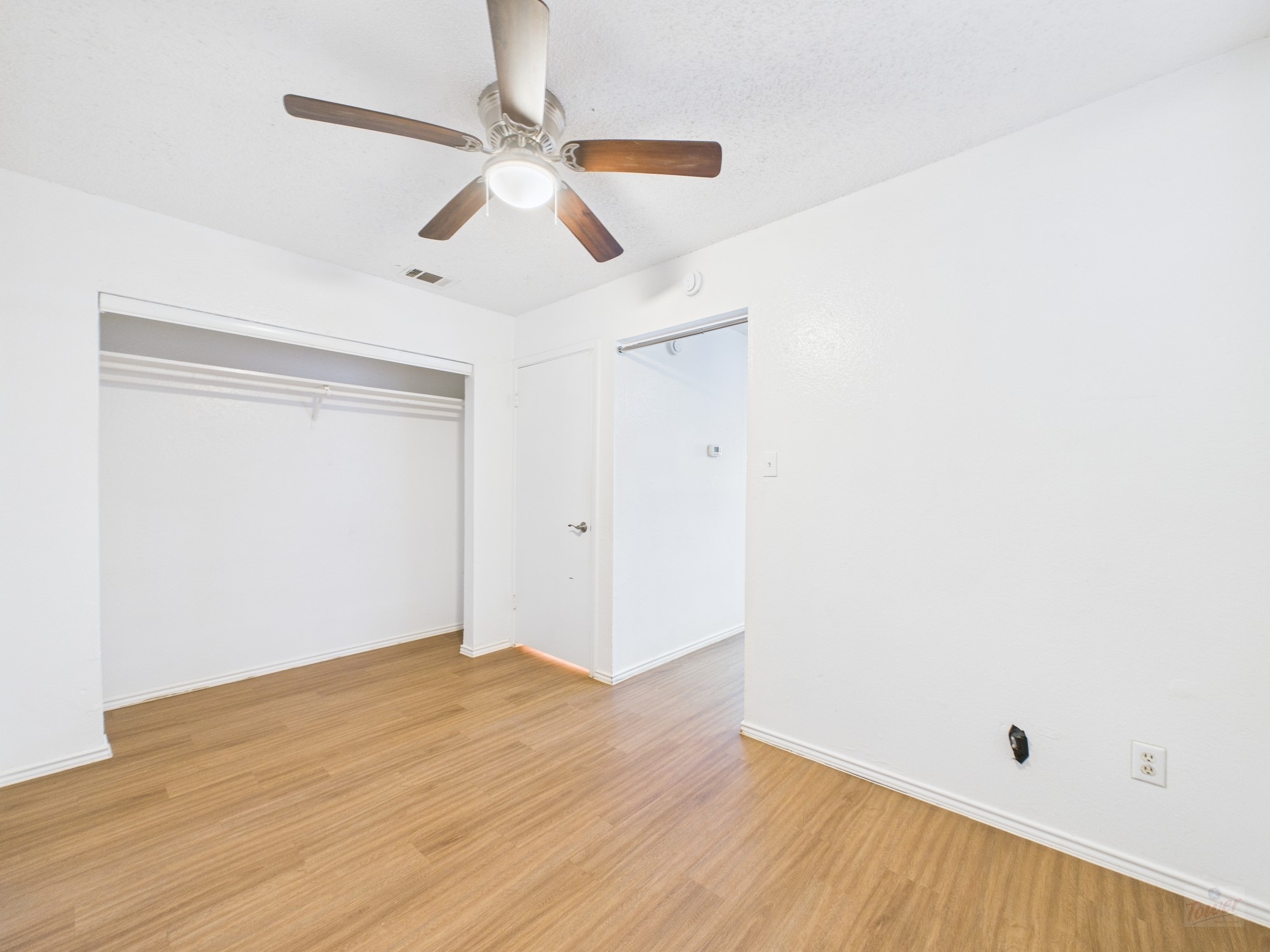 2500 Burleson Road, Unit 201 Austin, TX 78741 - Photo 14 of 20 an empty room with wooden floor fan and windows