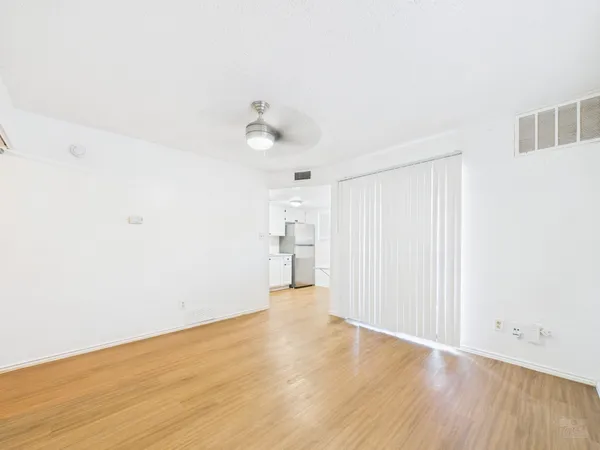 a view of an empty room with wooden floor