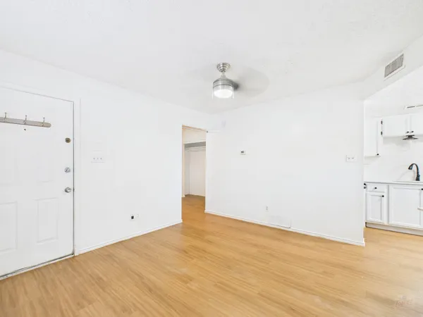 a view of empty room with wooden floor