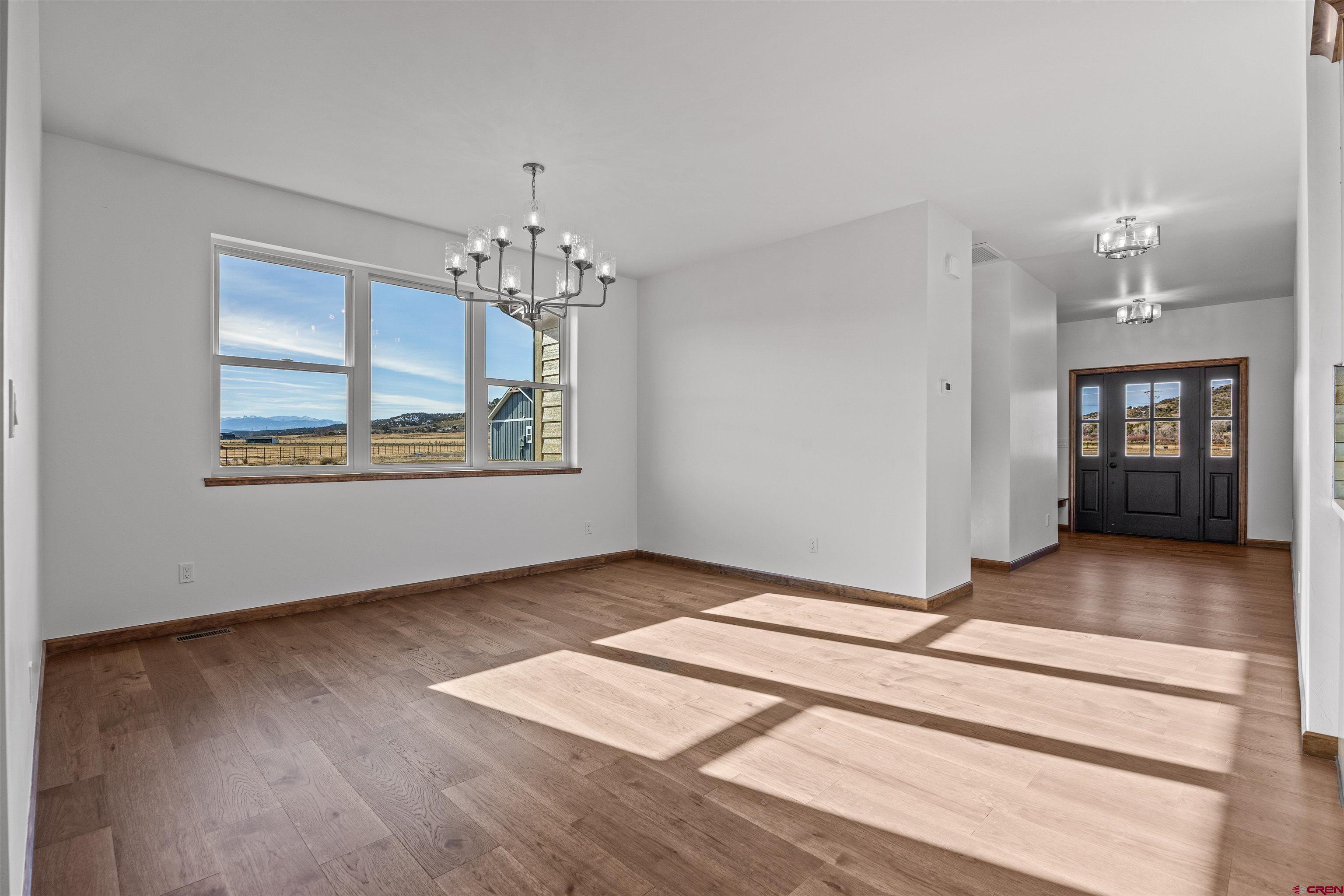 21470 Government Springs Road Montrose, CO 81403 - Photo 1 of 42 a view of an empty room with window and wooden floor