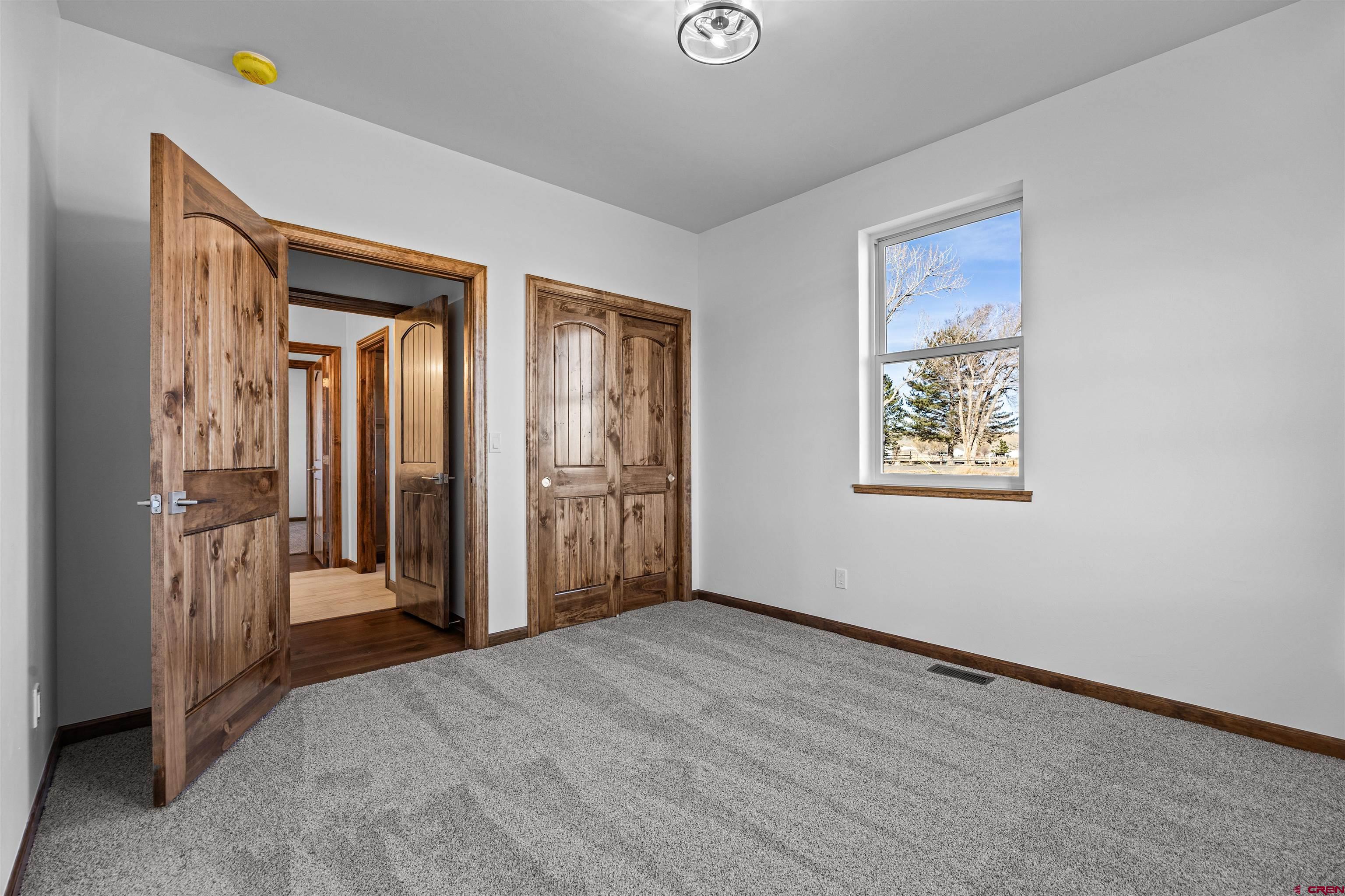21470 Government Springs Road Montrose, CO 81403 - Photo 28 of 42 a view of a hallway with wooden floor and closet