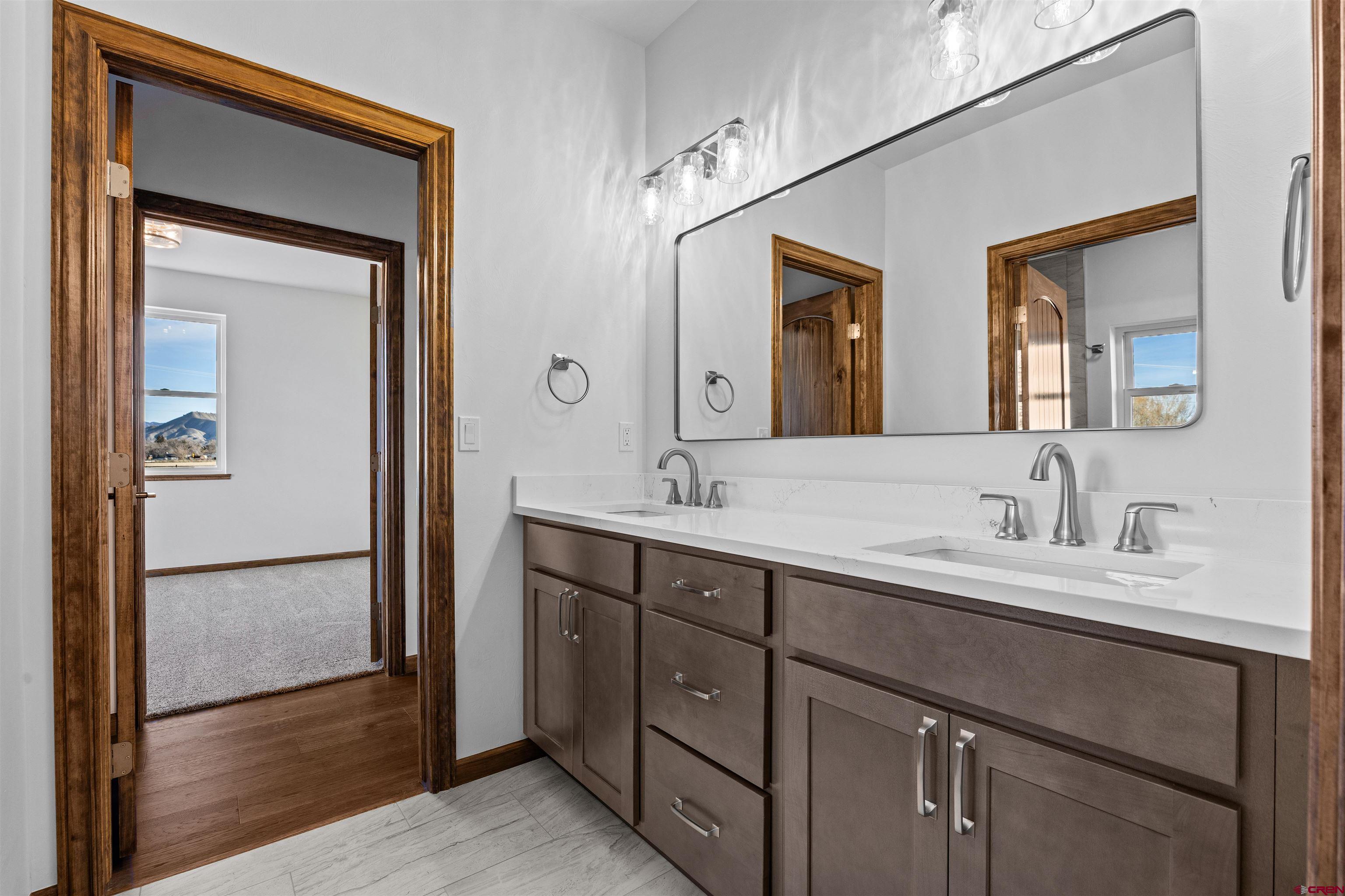 21470 Government Springs Road Montrose, CO 81403 - Photo 29 of 42 a bathroom with a double vanity sink and a mirror