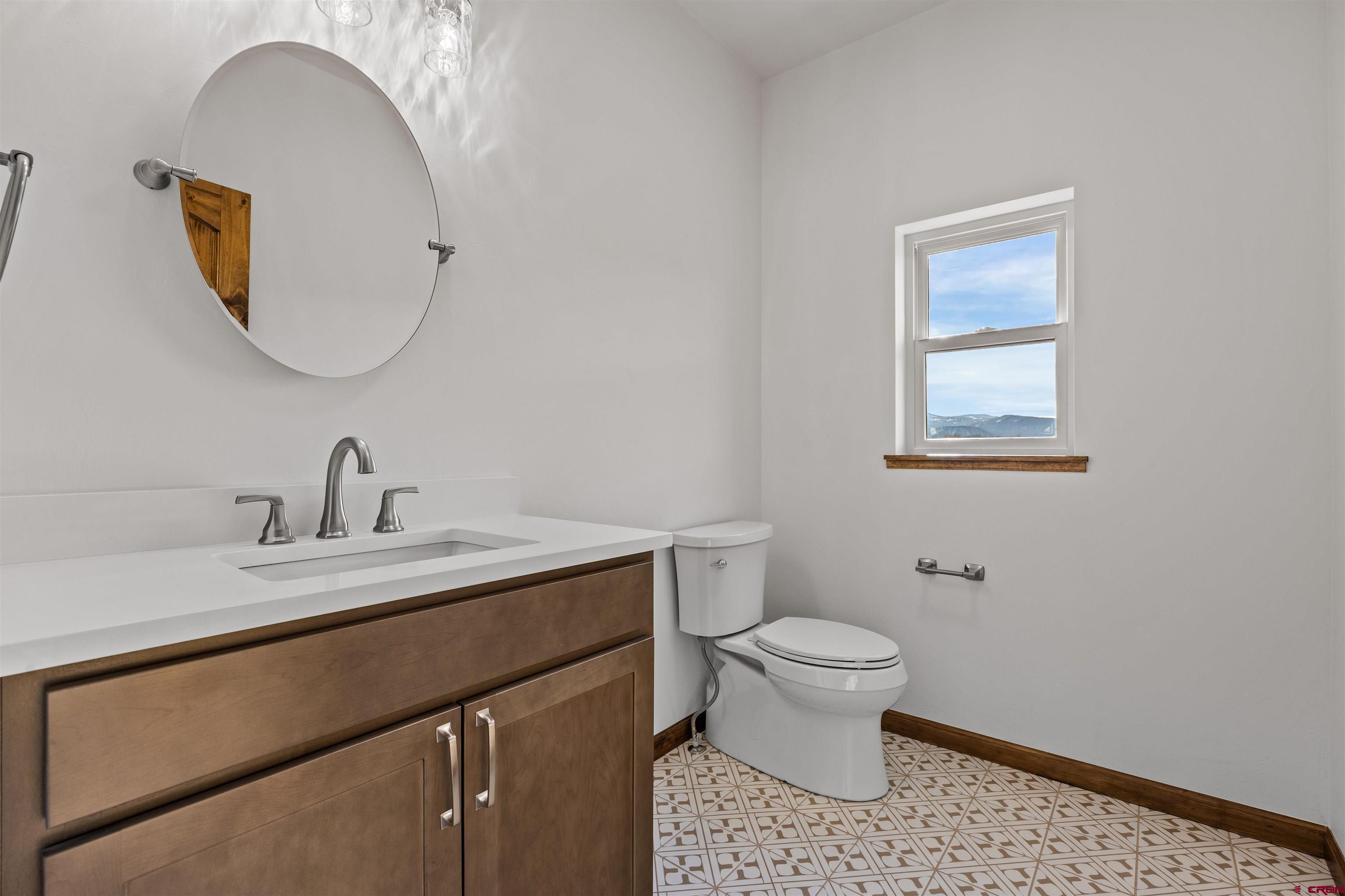 21470 Government Springs Road Montrose, CO 81403 - Photo 32 of 42 a bathroom with a sink a toilet and a mirror