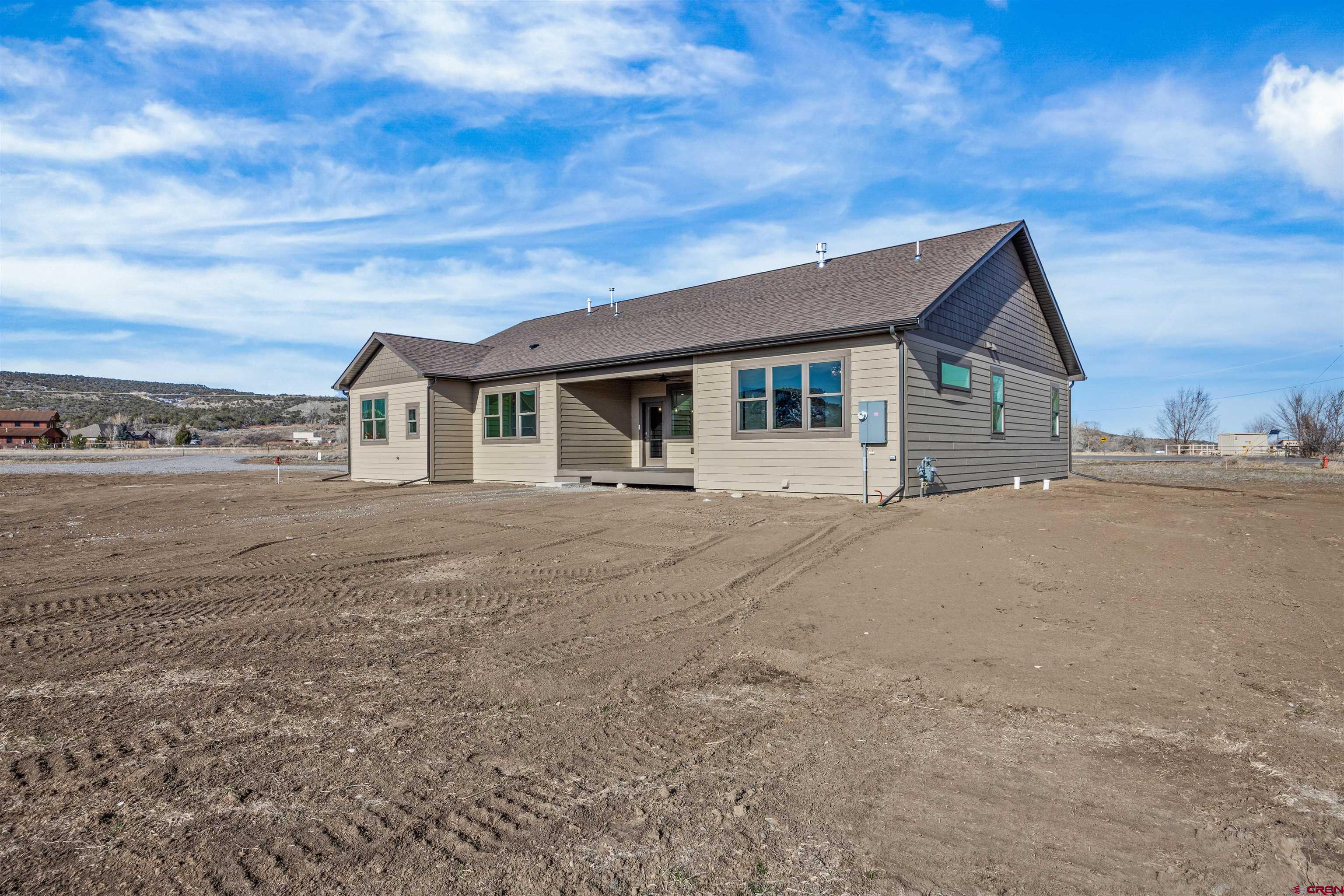 21470 Government Springs Road Montrose, CO 81403 - Photo 36 of 42 a view of house with backyard and bushes